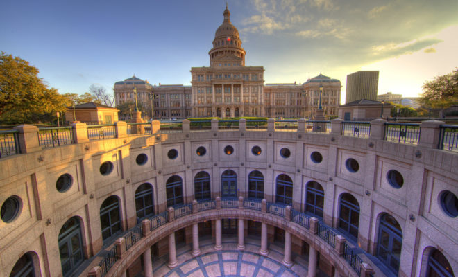 The Texas Capitol viewed across the circular Capitol Extension courtyard in warm evening light